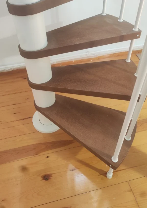 Peldaños de escalera de caracol de madera color nogal y estructura blanca