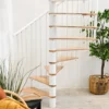 Escalera de caracol blanca con peldaños de madera integrada en salón de estilo nórdico, perfecta para espacios modernos.